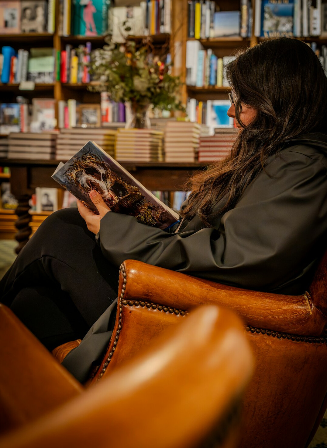 woman reading book in armchair